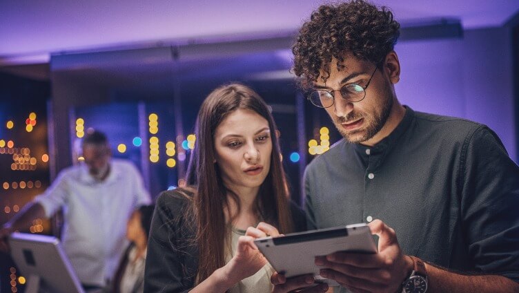 Zwei Personen schauen auf ein Tablet
