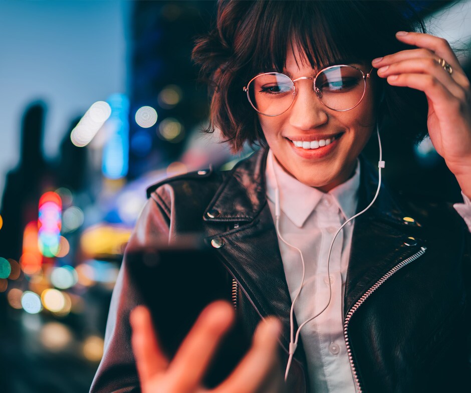 Person, die auf ihr Telefon schaut und lächelt