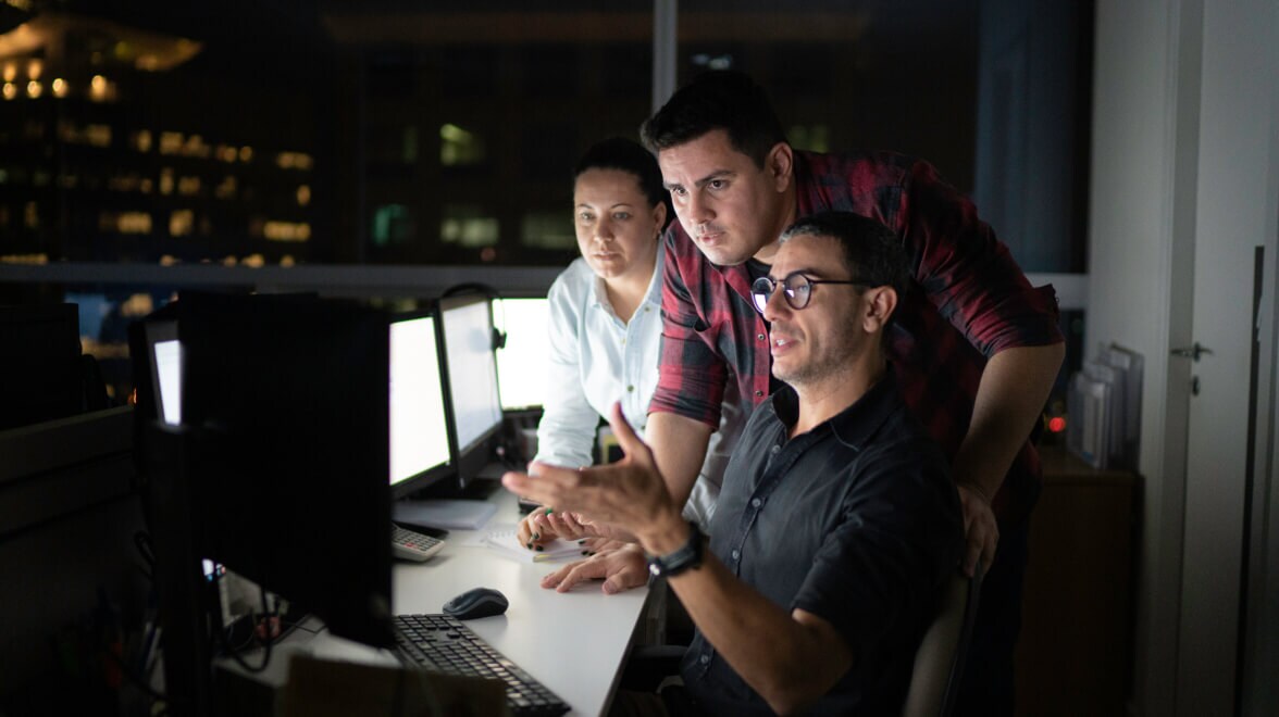 Ein paar Leute unterhalten sich, während sie auf den Monitor schauen.
