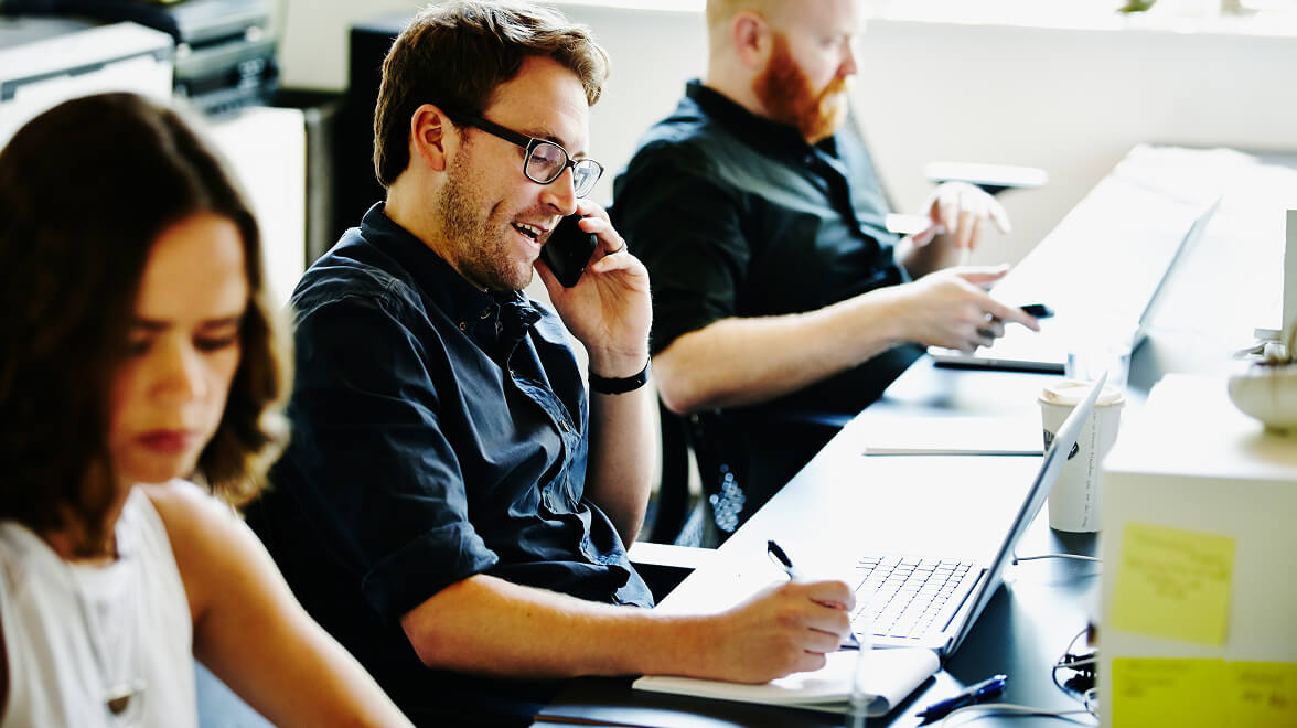 Ein paar Leute sitzen im Büro und arbeiten