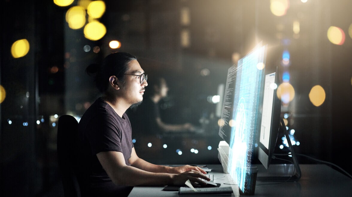 Una persona que mira el monitor y trabaja