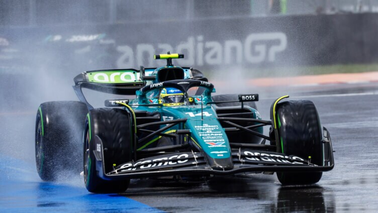 conductor sentado dentro de un coche de carreras en la pista