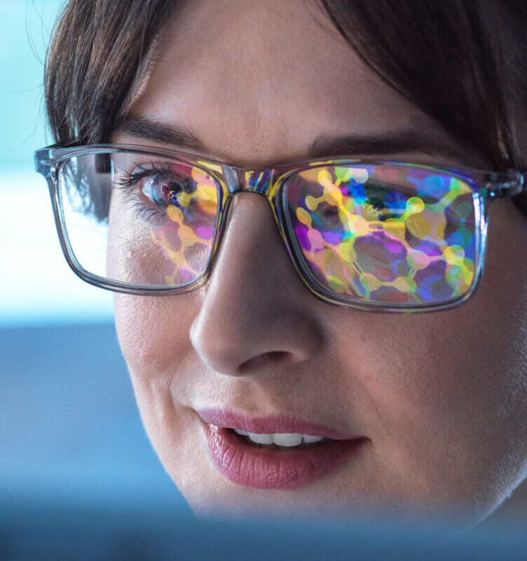 Gros plan sur des lunettes portées par une personne travaillant sur un ordinateur.