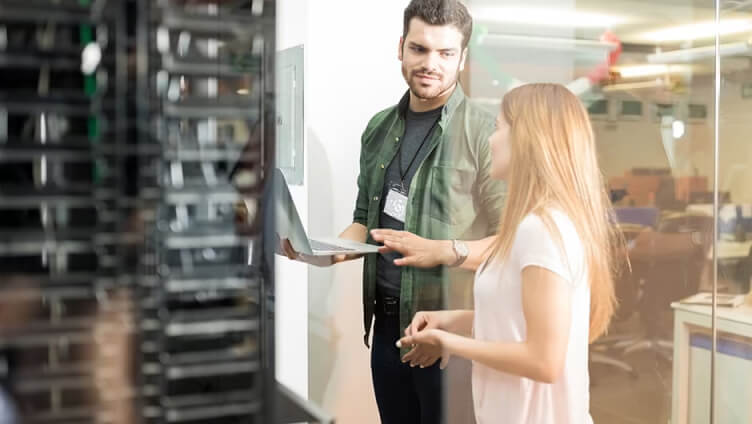 personnes avec un ordinateur portable discutant dans un espace de data center