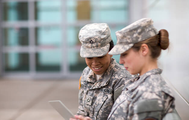 Two Military people sitting and seeing the iPad