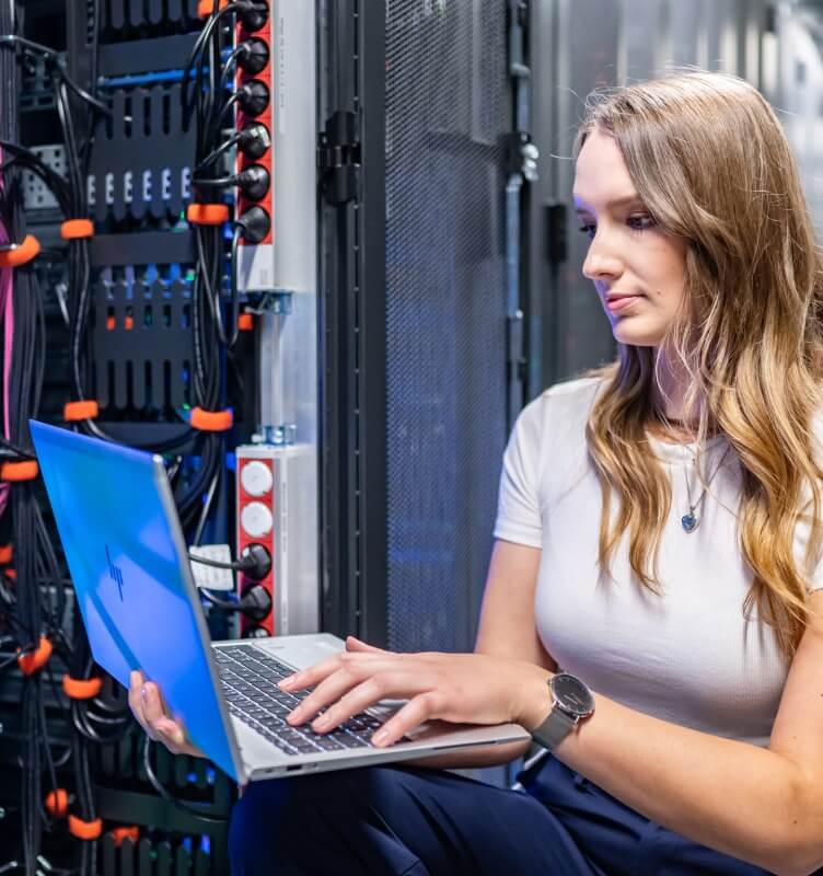 Donna con notebook in un data center