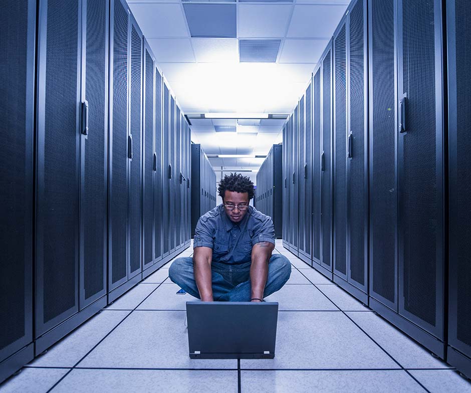 persona che lavora con un laptop nel data center