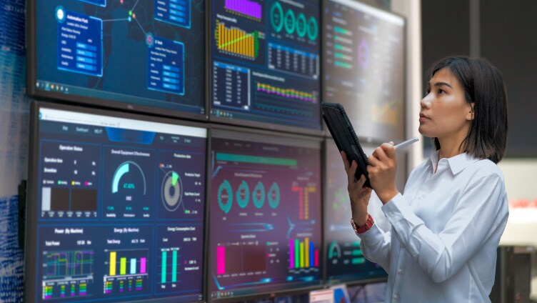 複数の画面でデータを見ている女性