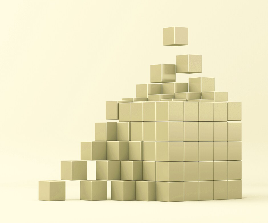 柔らかい黄色の背景に、小さな金色のブロックが集まっています より大きな金の立方体を形成します