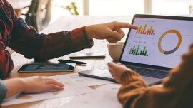 그래프가 있는 노트북 화면을 보고 토론하는 사람들