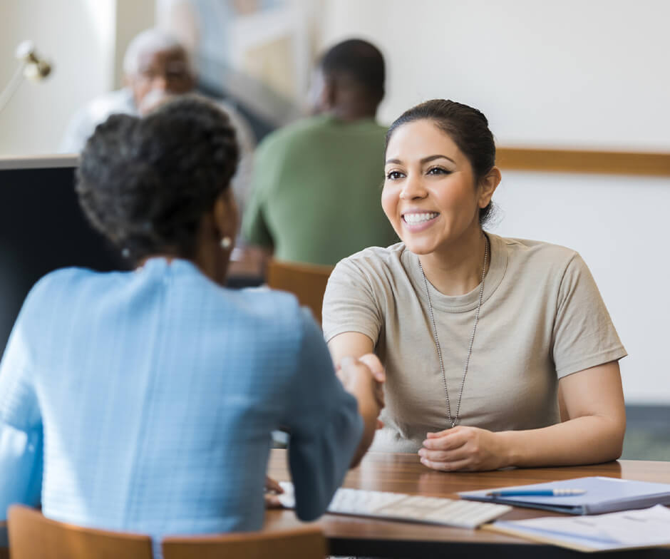 Two people sitting and giving handshake to each other