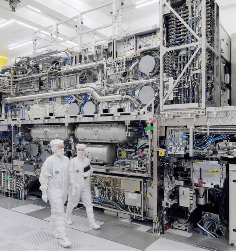 Two persons walking in the machinery room with completely covered clothes