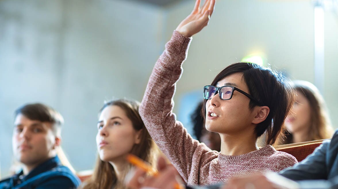 Student raising hand in classroom