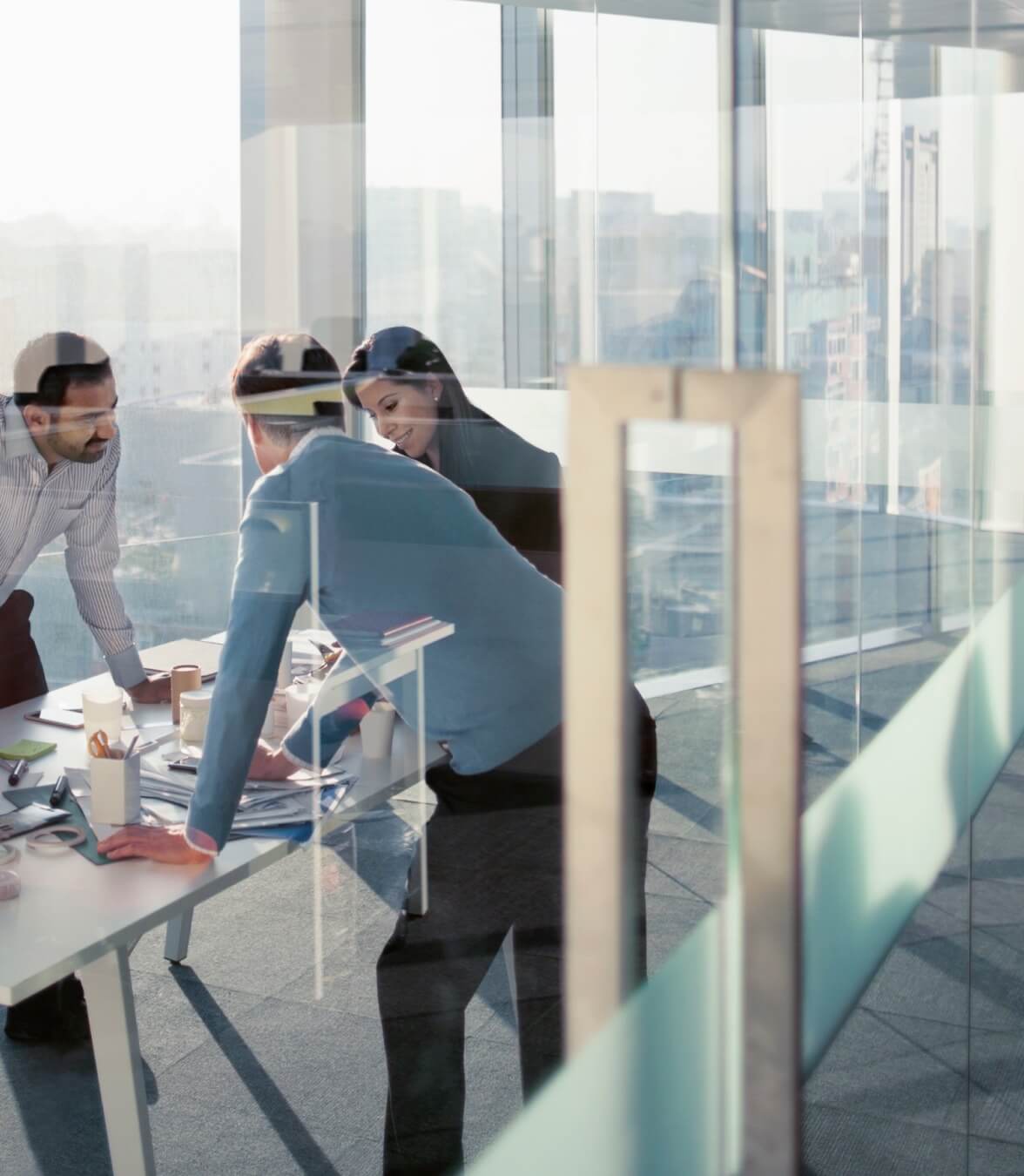 Three professionals standing over an office table