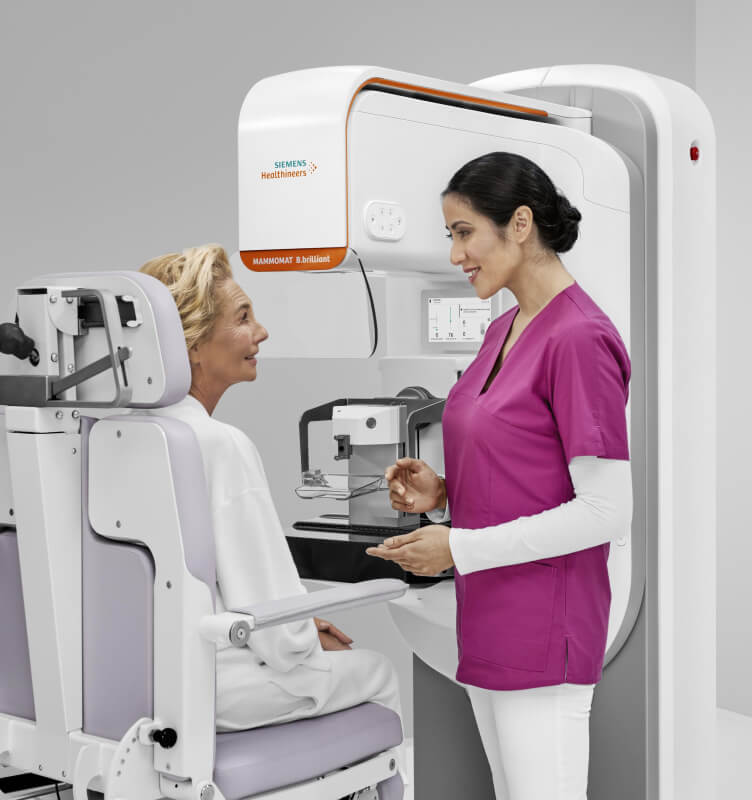 A patient and a medical worker with a Siemens Healthineers mammography machine