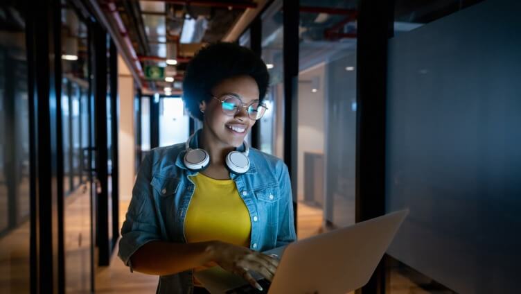 A Person standing holding a laptop looking into it