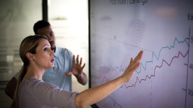 two people looking at white board