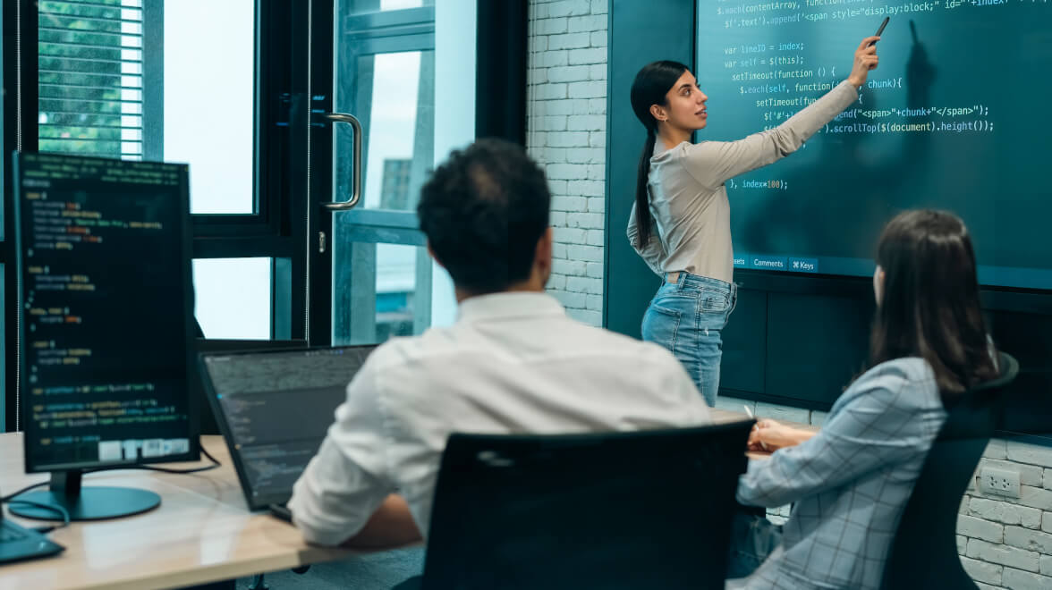 A Person in the meeting room explaining on the black board