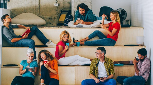 group of people sitting on stairs and looking at items in their hands