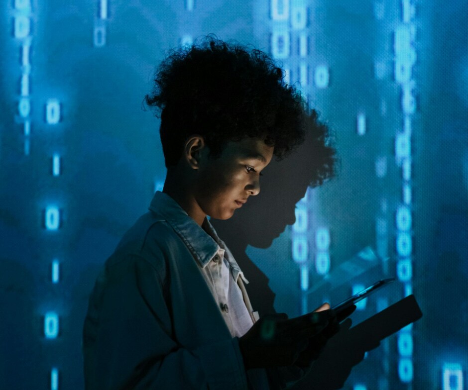 Person using a digital tablet against a blue data and binary code background, representing artificial intelligence, cybersecurity, and data protection technology.