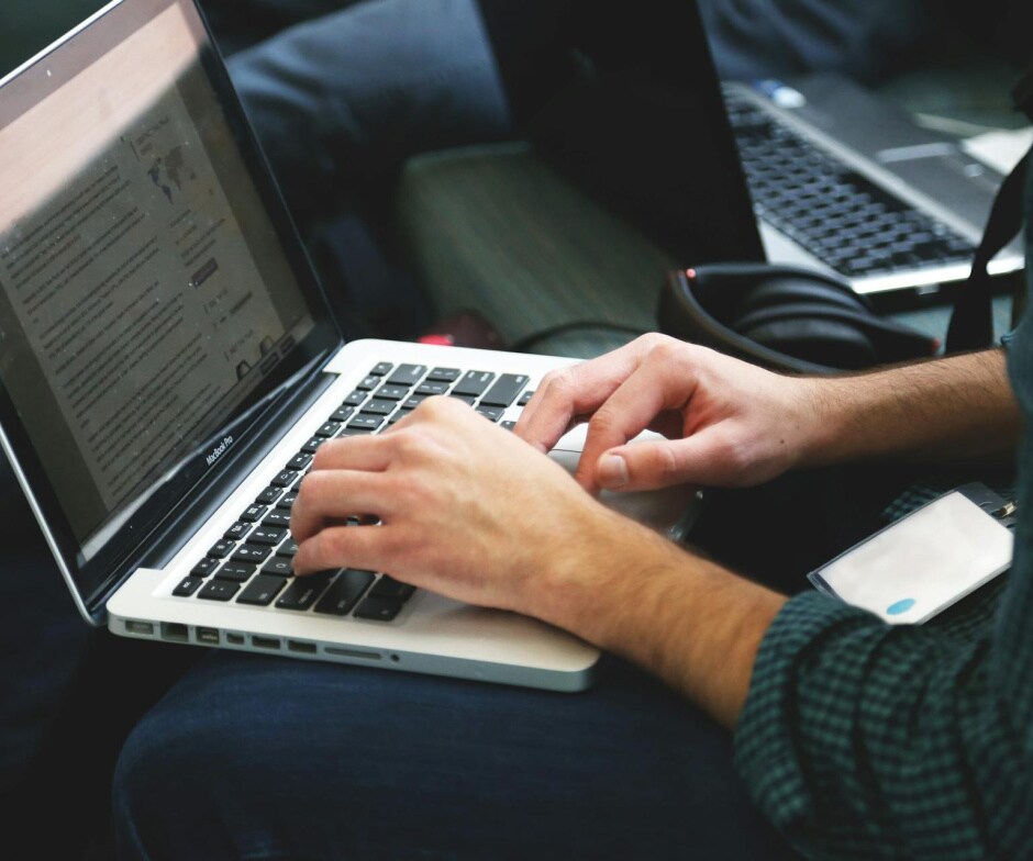 Person typing on a laptop computer during a work or study session.