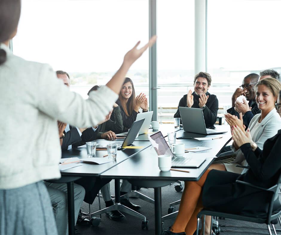 professional presenting to people at conference table