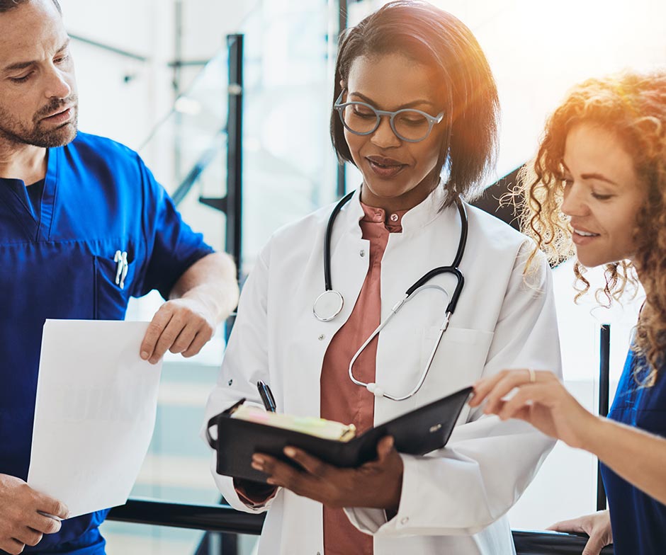 doctor with a nurse on either side reviewing information together