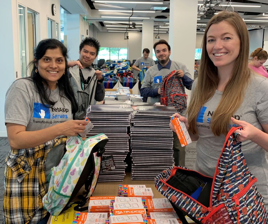 Pessoas embalando mochilas escolares com material escolar
