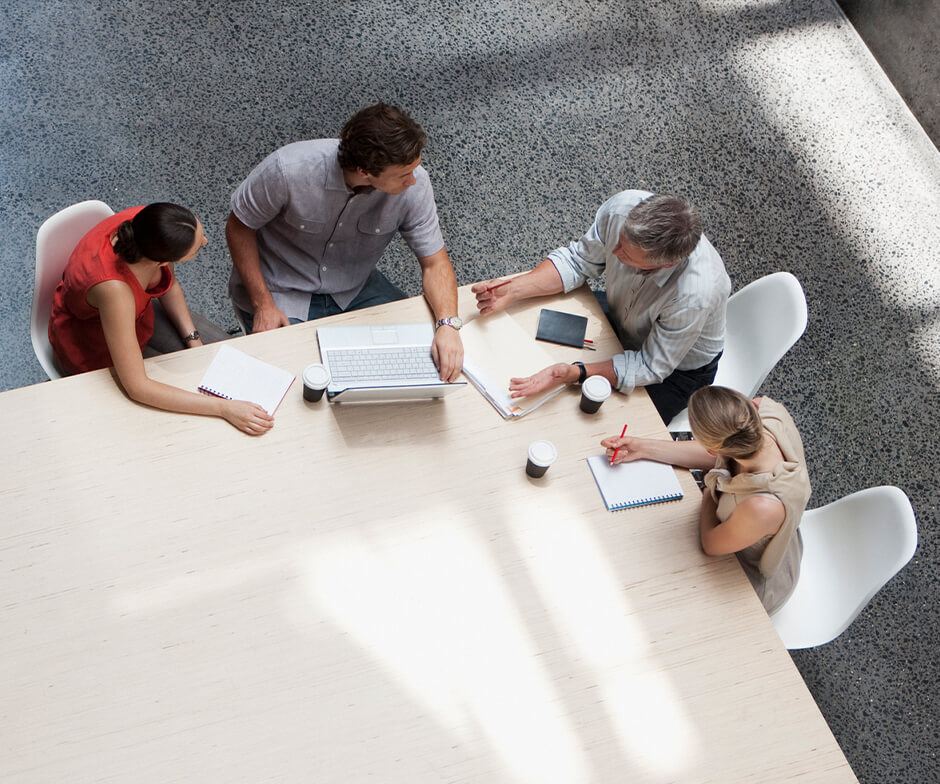 quatro pessoas discutindo o trabalho em uma mesa