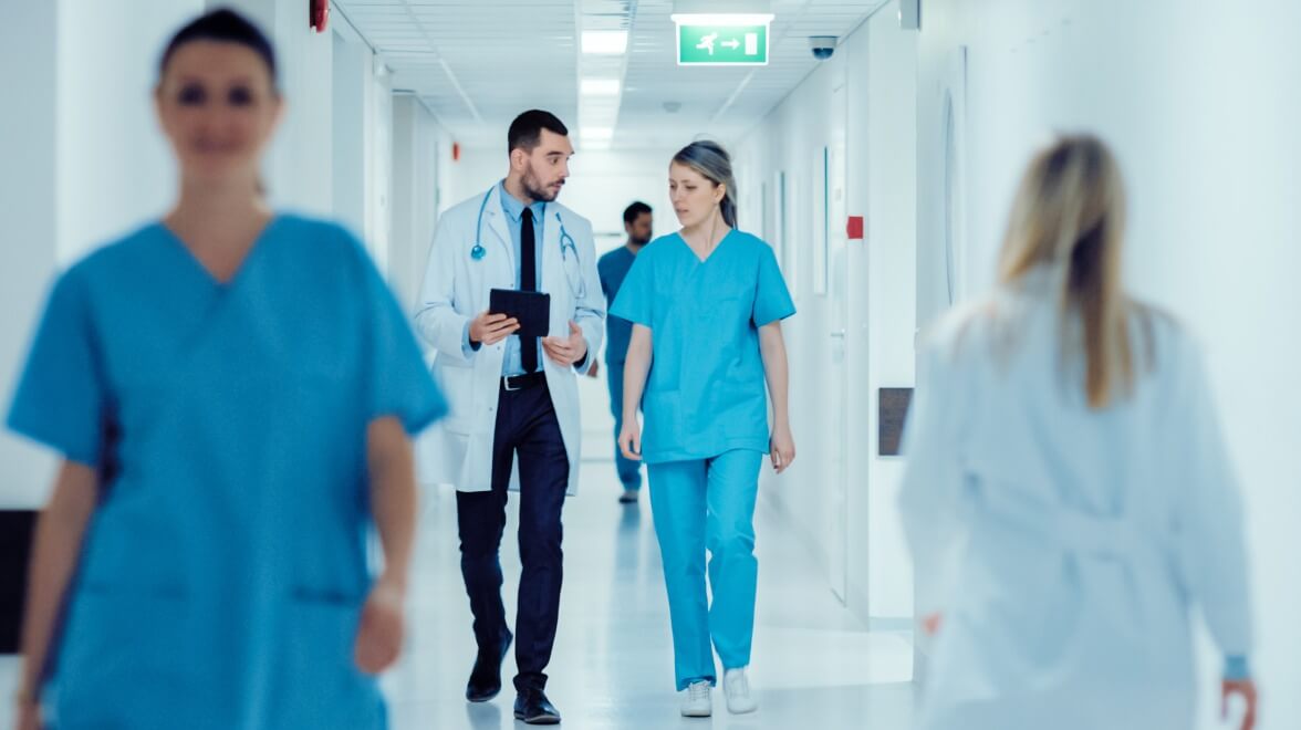 médicos caminhando pelo corredor enquanto discutem