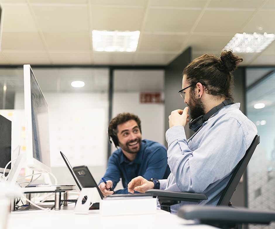 两个人坐在办公桌前聊天