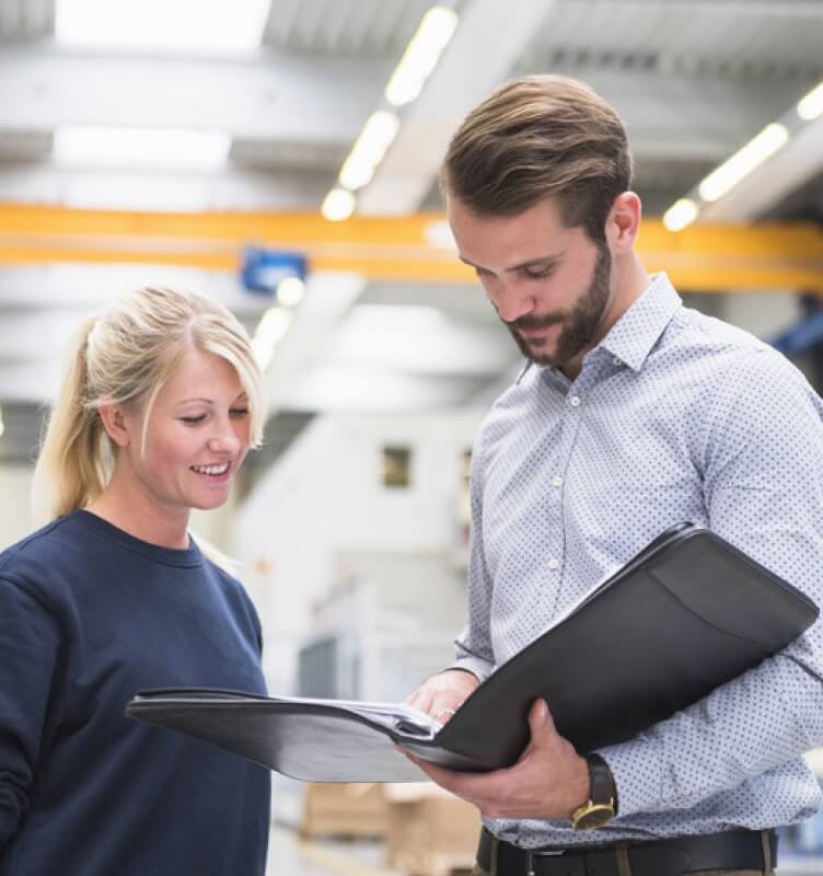 兩位 STRAMA 員工正在查看一份文件