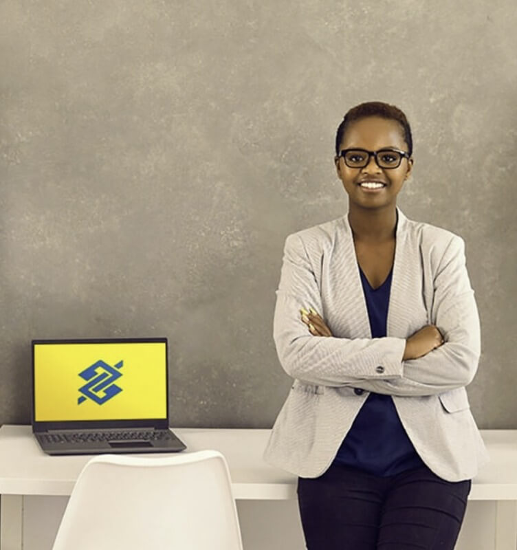 一位女士站在放著筆記型電腦的桌子旁